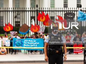 A US Park Police officer guards Native American climate activists and allies waiting to be arrested at the White House during a civil disobe...