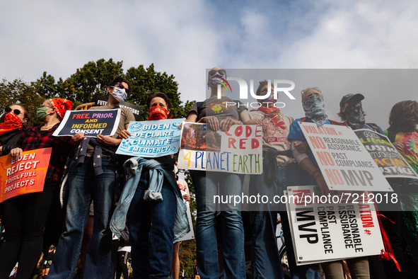 Allies of Native American climate activists form a protective wall around as they speak during a protest at the White House action against t...