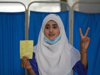 A school student shows the V sign at Colonel Malek Medical College Hospital after received a dose of the Covid-19 coronavirus vaccine as tri...