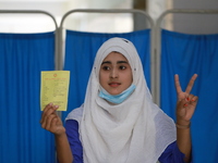 A school student shows the V sign at Colonel Malek Medical College Hospital after received a dose of the Covid-19 coronavirus vaccine as tri...