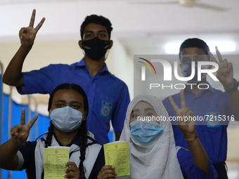 School students show the V sign at Colonel Malek Medical College Hospital after received a dose of the Covid-19 coronavirus vaccine as trial...