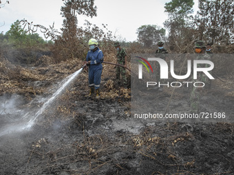 An Indonesian military spray water on forest burned area at Rimbo Panjang Village, Kampar,  Riau, Indonesia, at August 06. 2015. During Indo...