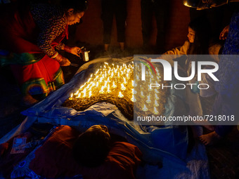 A Nepalese Hindu devotee lies on the ground with burning oil lamps as part of rituals to celebrate the tenth day of Dashain Festival  at Bar...