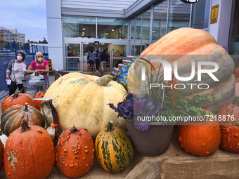 Women look at giant pumpkins displayed outside a supermarket during the Autumn season in Markham, Ontario, Canada, on October 15, 2021. (