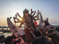 Hindu devotees prepare to immerse an idol of the Hindu Goddess Durga in the Buriganga River on the final day of the Durga Puja festival in D...