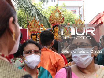 Indian hindu Devotees warring facemask agaist coronavirus and  participate in the hindu goddess Durga idol immersion at Ganga river in Kolka...