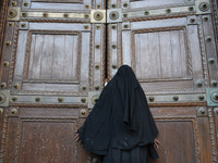 A Kashmiri women stands outside Kashmir's grand mosque Jamia Masjid after authorities disallowed the friday prayers in Srinagar, Indian Admi...