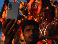 A Hindu devotee takes selfie  with a clay idol of the Hindu Goddess Durga on the last day of Durga Puja Festival, on October 15, 2021 in Bar...