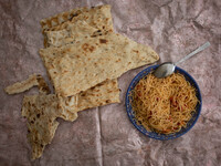 Bread and spaghetti that has cooked without meat, which is the main meal for Abdolghani Jamshidi-60, An Afghan refugee who works as a constr...