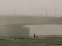 people walk along the bank of rhine river during the foggy day in Cologne, Germany on Oct 16, 2021 (
