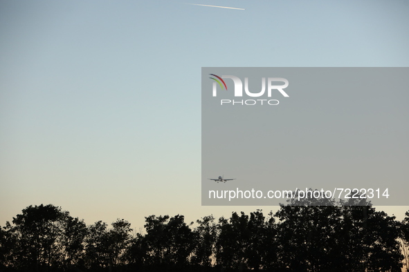 A plane flyes above the trees during the evening hours in Stuttgart, Germany on October 9, 2021 
