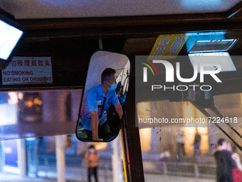 A tram conductor is seen in his mirror while operating his tramways in Central Hong Kong. (