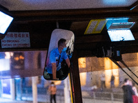 A tram conductor is seen in his mirror while operating his tramways in Central Hong Kong. (