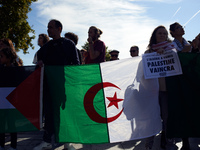 Protesters hold Agerian flags. Dozens of protesters walk to commerorate the 60th anniversary of the slaughter of algerian protesters by Fren...