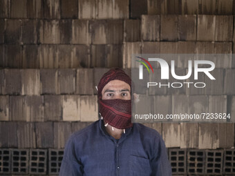 An Afghan refugee labor poses for a photograph while working in a brick factory, in the Borkhar area in the west of the city of Isfahan 439K...