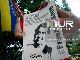 A man holds a sign calling for the release of Alex Saab at a rally in solidarity with the Colombian businessman following his extradition to...