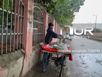 Rishik, 21, a Non-Local worker selling snacks outside a Shrine in Sopore, District Baramulla, Jammu and Kashmir, India on 18 October 2021. 2...