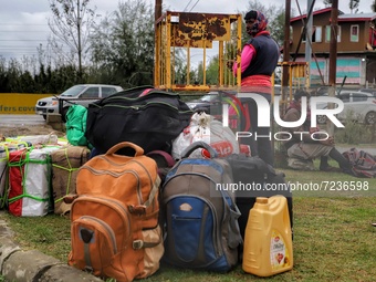 Non-Local Laborers wait outside a Railway Station with all their belongings in Sopore, District Baramulla, Jammu and Kashmir, India on 18 Oc...
