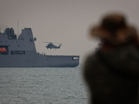 Royal New Zealand Air Force SH-2G(I) Seasprite maritime helicopter prepares to land on the HMNZS Aotearoa naval vessel at Marina South on Oc...