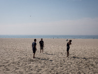 Three men are playing with a ball at Matosinhos beach on October 18, 2021, a city and a municipality in the northern Porto district of Portu...