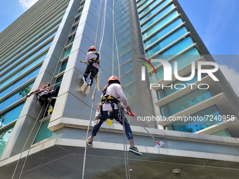 Foriegn workers clean a building facade in Singapore, on Tuesday, 19 October 2021. The U.S. Centers for Disease Control and Prevention (CDC)...
