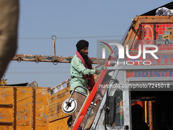 A Sikh driver cleans the windshield of his truck at Fruit mandi in Sopore, District Baramulla, Jammu and Kashmir, India on 20 October 2021....