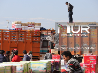 A Non-Local loads a truck with Apple boxes at Fruit mandi in Sopore, District Baramulla, Jammu and Kashmir, India on 20 October 2021. Trader...