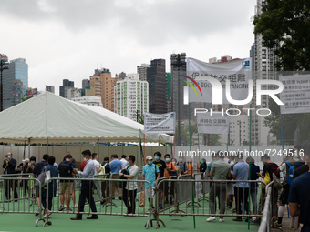 Runners prepare for registration in Victoria Park to compete in the Hong Kong marathon by queuing under banners warning to keep social dista...