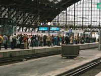 travellers wait for the train arriving in cologne central station as some of long distance bahns service suspends or delays during the autum...