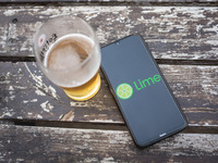 In this photo illustration a Lime logo is display on a smartphone screen and a glass of beer in Sintra, Portugal on October 21, 2021. (
