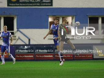 Barrow's James Jones contests a header with Scunthorpe United's Jake Scrimshaw during the Sky Bet League 2 match between Barrow and Scunthor...