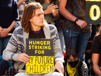 Hunger strikers hold signs with the reason(s) they are striking at a rally to support them.  The 5 people on hunger strike at the White Hous...
