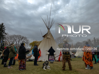 People seen during a prayer ceremony in a 'sit-in' camp that consists of five teepees, a dozen tents and a sacred fire, set in the Alberta L...