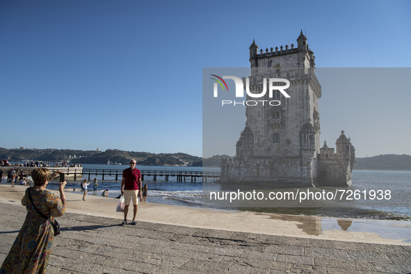 Two people take photographs near the tourist area of the Belem Tower, Lisbon. 20 October 2021. Most regions in mainland Portugal show an 