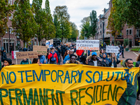 Around a hundred of people are walking while holding a big banner asking for permanent residency, during a demonstration organized by the gr...