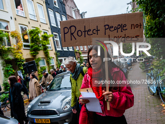 A woman is holding a placard asking for permanent residency, during a demonstration organized by the group 'We Are Here' to demand permanent...