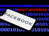 Facebook company logo displayed on a phone screen and a binary code with the word 'metaverse' displayed on a laptop screen are seen in this...