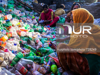 Women workers recycling plastic products mainly plastic bottles in a local factory in Dhaka, Bangladesh, on 11 August 2015
 (