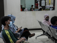 Indonesian people sit for observation after receiving an injection of the Pfizer-BioNTech Comirnaty COVID-19 vaccine during a mass vaccinati...