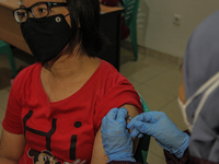 A health worker injects a woman with a dose of Pfizer-BioNTech Comirnaty COVID-19 vaccine against the coronavirus disease (COVID-19) during...