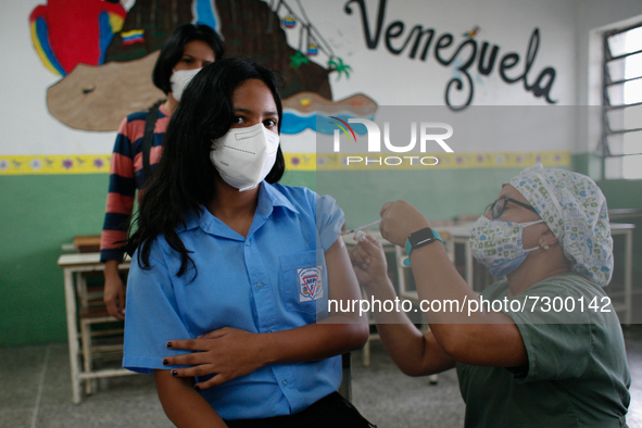 A student is immunized against Covid-19 with the Chinese-made compound Sinopharm at a high school in the west of the city, in Caracas, Venez...