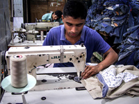 Bangladeshi local boutique workers making clothes and painting them at Dhaka,  Bangladesh on 12 August 2015.These clothes are then distribut...