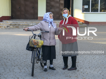 Two women in protective masks talking on the street in the Rososha village, Ukraine. October 2021 Daily life in Ukraine amid the outbreak of...