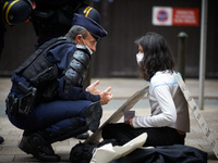 A riot policeman speaks to an XR activits after removing her from the street. Her placard reads 'I'm terrified by disasters'. XR France (Ext...