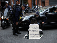 Riot policemen try to convince a XR activist to quit the road as she blocks it. Her placard reads 'I'm terrified by disaster more numerous a...