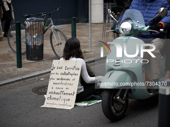 A XR activist block a street in toulouse. Her placard reads 'I'm terrified by disasters more numerous and more deadly caused by the global w...