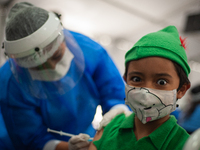 A child using a Peter Pan Costume during halloween gets his first dose of the COVID-19 vaccine as the Colombian government begins to vaccina...