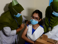 A Bangladeshi school student receives a first dose of the Pfizer COVID-19 vaccine at the Ideal School and College center in the Motijheel ar...