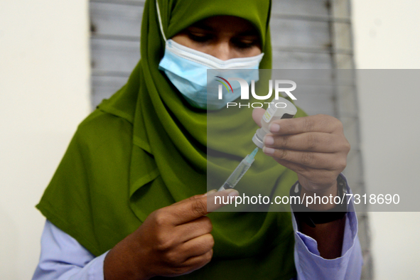 A healthcare worker prepares a dose of the Pfizer COVID-19 vaccine during the vaccination campaign at the Ideal School and College center in...