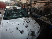 Palestinians look at the remains of a destroyed metal workshop in Gaza city Witnesses said three rockets were fired at Ashkelon from the Gaz...